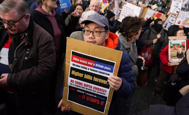 Demonstrators hold placards and flags as they attend a protest against the proposed Chinese embassy, in London, Saturday, Jan. 17, 2026. (AP Photo/Alberto Pezzali)