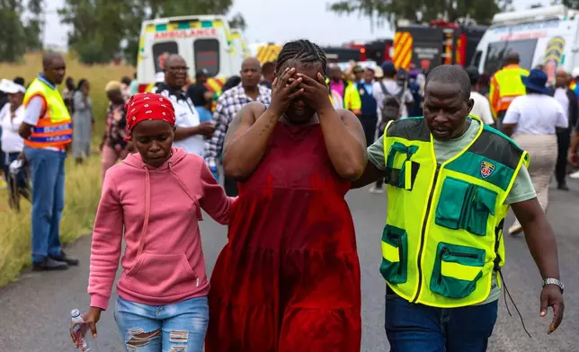Relatives of school children who died when the minibus they were riding in collided with a truck, weep at the scene of the crash in Vanderbijlpark, South of Johannesburg, South Africa, Monday, Jan. 19, 2026. (AP Photo)