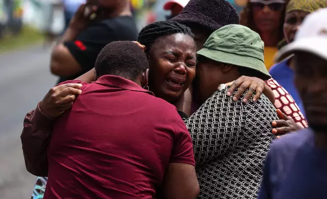 Relatives of school children who died when the minibus they were riding in collided with a truck, weep at the scene of the crash in Vanderbijlpark, South of Johannesburg, South Africa, Monday, Jan. 19, 2026. (AP Photo)