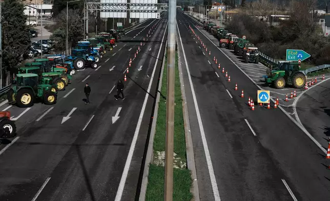 Tractors block a highway as farmers protest in Kastro, about 130 kilometers (81 miles) north of Athens, Greece, over delays in the payment of European Union-backed agricultural subsidies, on Thursday, Jan. 8 2025. (AP Photo/Thanassis Stavrakis)