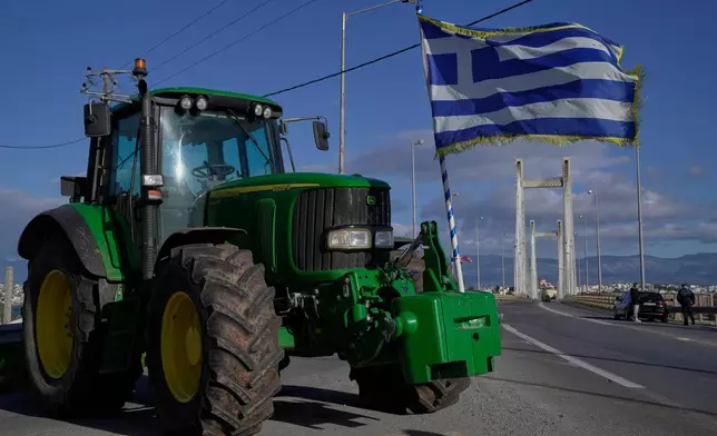 A tractor with a Greek flag blocks the Chalkida Bridge as farmers protest over delays in European Union–backed agricultural subsidy payments, on Evia island, Greece, Thursday, Jan. 8, 2026. (AP Photo/Thanassis Stavrakis)