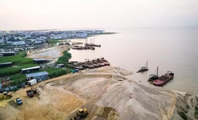 Aerial view of heaps of sand and dredging equipment in the busy Ajah area of Lagos, Nigeria, on Saturday, Dec. 6, 2025. (AP Photo/Grace Ekpu)