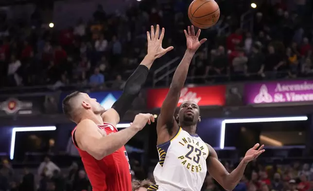 Indiana Pacers guard Aaron Nesmith (23) shoots over Chicago Bulls center Nikola Vucevic (9) during the first half of an NBA basketball game in Indianapolis, Wednesday, Jan. 28, 2026. (AP Photo/Michael Conroy)