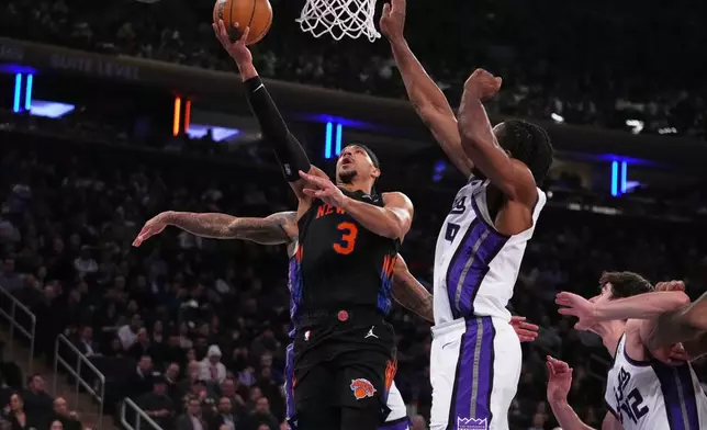 New York Knicks' Josh Hart (3) drives past Sacramento Kings' Precious Achiuwa (9) and Maxime Raynaud (42) during the first half of an NBA basketball game Tuesday, Jan. 27, 2026, in New York. (AP Photo/Frank Franklin II)