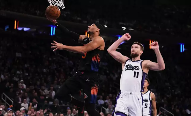 New York Knicks' Josh Hart, left, drives past Sacramento Kings' Domantas Sabonis during the first half of an NBA basketball game Tuesday, Jan. 27, 2026, in New York. (AP Photo/Frank Franklin II)