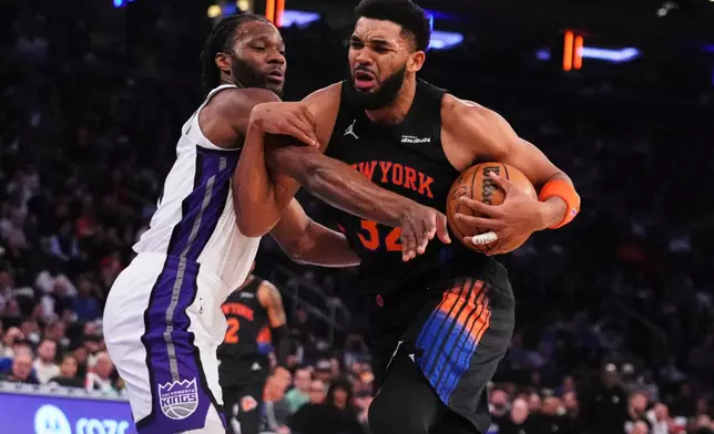 Sacramento Kings' Precious Achiuwa, left, defends New York Knicks' Karl-Anthony Towns during the first half of an NBA basketball game Tuesday, Jan. 27, 2026, in New York. (AP Photo/Frank Franklin II)
