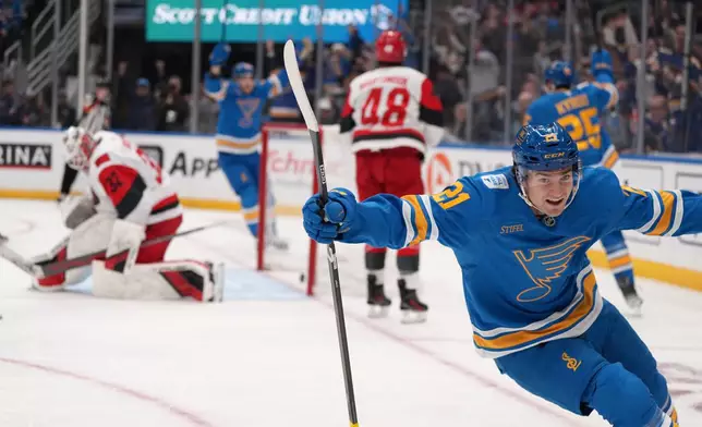 St. Louis Blues' Jimmy Snuggerud (21) celebrates after scoring past Carolina Hurricanes goaltender Brandon Bussi (32) during the second period of an NHL hockey game Tuesday, Jan. 13, 2026, in St. Louis. (AP Photo/Jeff Roberson)