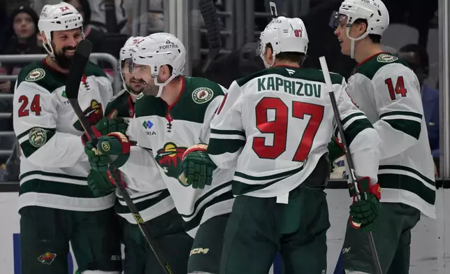 Minnesota Wild defenseman Jake Middleton, center, is congratulated after scoring during the first period of an NHL hockey game against the Los Angeles Kings, Saturday, Jan. 3, 2026, in Los Angeles. (AP Photo/Jayne Kamin-Oncea)