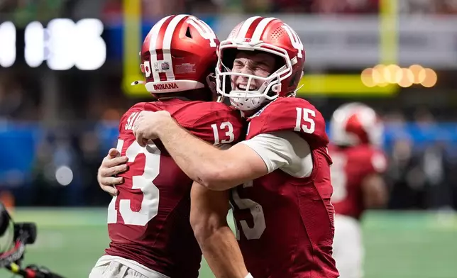 Indiana wide receiver Elijah Sarratt (13) celebrates his touchdown reception with quarterback Fernando Mendoza (15) during the second half of the Peach Bowl NCAA college football playoff semifinal, Friday, Jan. 9, 2026, in Atlanta. (AP Photo/Mike Stewart)
