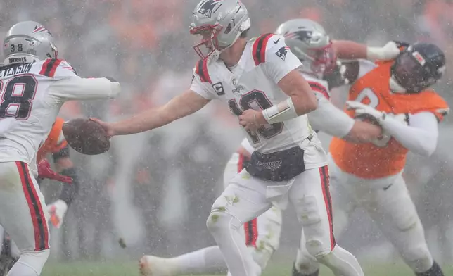 New England Patriots quarterback Drake Maye (10) hands off against the Denver Broncos during the second half of the AFC Championship NFL football game, Sunday, Jan. 25, 2026, in Denver. (AP Photo/David Zalubowski)
