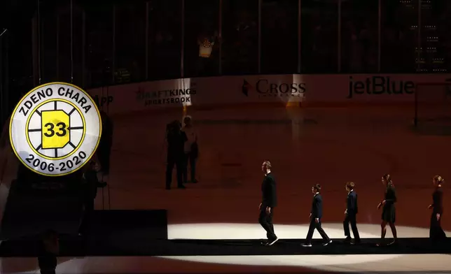 Former Boston Bruins captain Zdeno Chara leads his family over to his number "33" to raise it to the rafters before an NHL hockey game between the Boston Bruins and the Seattle Kraken, Thursday, Jan. 15, 2026, in Boston. (AP Photo/Winslow Townson)
