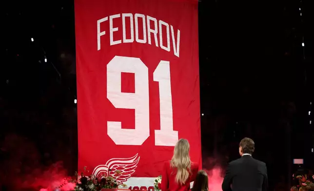 CORRECTS TO SERGEI FEDOROV NOT SERGEI FEDEROV - Former Detroit Red Wings player Sergei Fedorov, right, stands with his wife Karina, left, and children Alexandra and Viktor during his jersey retirement ceremony before an NHL hockey game against the Carolina Hurricanes, Monday, Jan. 12, 2026, in Detroit. (AP Photo/Ryan Sun)
