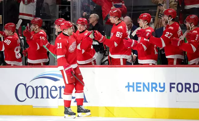 Detroit Red Wings left wing James van Riemsdyk (21) celebrates with the bench after scoring during the first period of an NHL hockey game against the Carolina Hurricanes, Monday, Jan. 12, 2026, in Detroit. (AP Photo/Ryan Sun)