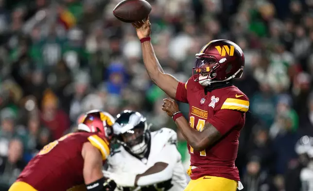 Washington Commanders quarterback Josh Johnson, right, passes against the Philadelphia Eagles during the second half of an NFL football game, Saturday, Dec. 20, 2025, in Landover, Md. (AP Photo/Nick Wass)