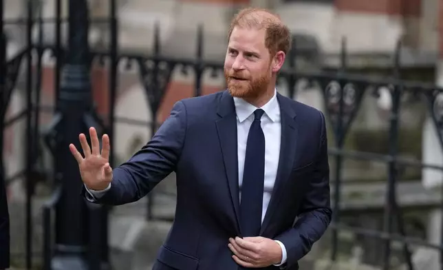 Britain's Prince Harry waves as he arrives at London's High Court to lead a group, including Elton John and Elizabeth Hurley, accusing the Daily Mail's publisher of privacy invasion through unlawful tactics in a trial that is part of a wider phone hacking scandal in London, Monday, Jan. 19, 2026. (AP Photo/Alastair Grant)