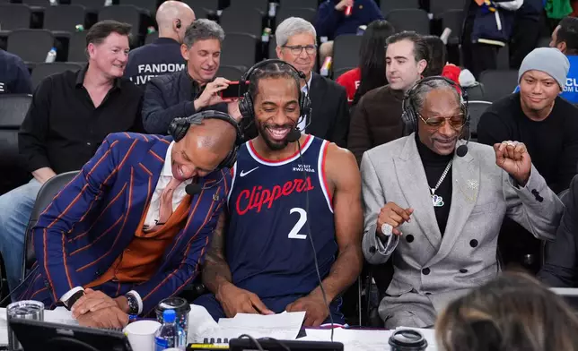 NBA analyst, Snoop Dogg, right, appears with Los Angeles Clippers forward Kawhi Leonard, center, and former NBA player and lead game analyst for NBC Sports, Reggie Miller, following the team's NBA basketball game against the Golden State Warriors, Monday, Jan. 5, 2026, in Inglewood, Calif. (AP Photo/Jae C. Hong)