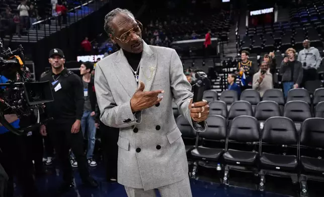 Debuting as an NBA analyst, Snoop Dogg, records video on the court before an NBA basketball game between the Los Angeles Clippers and the Golden State Warriors, Monday, Jan. 5, 2026, in Inglewood, Calif. (AP Photo/Jae C. Hong)