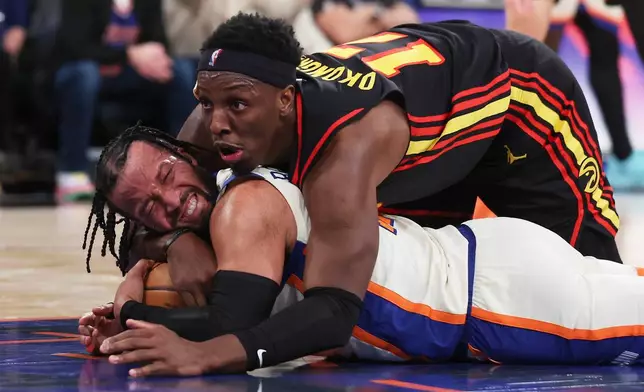 New York Knicks guard Jalen Brunson, bottom, and Atlanta Hawks forward Onyeka Okongwu (17) battle for the ball during second half of an NBA basketball game, Friday, Jan. 2, 2026, in New York. (AP Photo/Heather Khalifa)