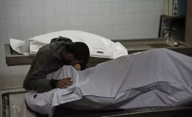 Magdi Abu Al-Khair bids farewell to his mother Amal Abu Al-Khair at Al-Shifa Hospital in Gaza City, Friday, Jan. 2, 2026, after she and her grandchild Saud were killed when their tent caught fire overnight at the Yarmouk displacement camp. (AP Photo/Jehad Alshrafi)