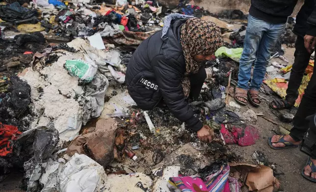 Fatima Abu al-Bayd inspects what remains of her mother's tent after her mother, Amal Abu Al-Khair, and grandchild, Saud, were killed when it caught fire overnight at the Yarmouk displacement camp in Gaza City, Friday, Jan. 2, 2026. (AP Photo/Jehad Alshrafi)