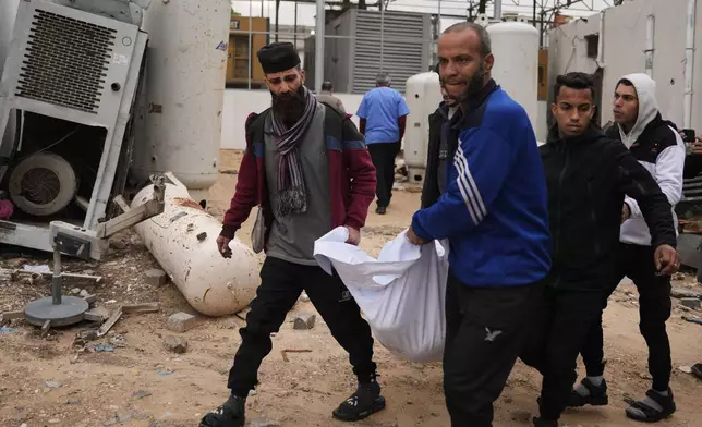 The bodies of Amal Abu Al-Khair and her grandchild, Saud, are transferred to Al-Shifa Hospital in Gaza City after they were killed when their tent caught fire overnight at the Yarmouk displacement camp, Friday, Jan. 2, 2026. (AP Photo/Jehad Alshrafi)