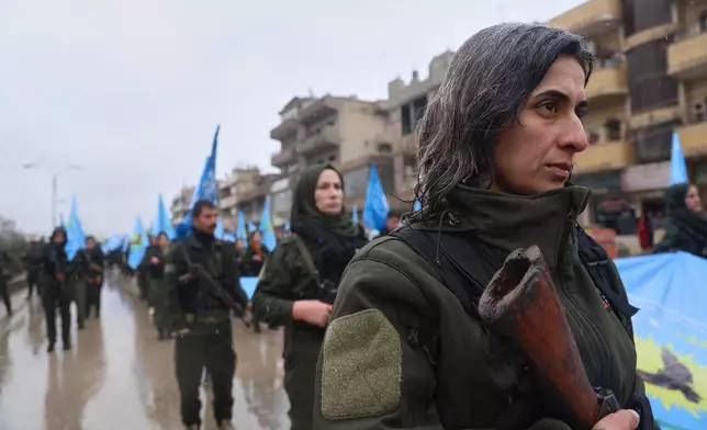 Female soldiers of the Kurdish-led, U.S.-backed Syrian Democratic Forces (SDF) march during a military parade in Qamishli, northeastern Syria, Sunday, Jan. 18, 2026. Syrian government forces have seized a strategic towns in eastern Syria, intensifying their push against Kurdish-led forces east of the Euphrates River.(AP Photo/Baderkhan Ahmad)