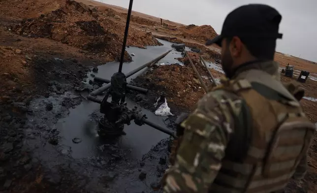 A Syrian government soldier walks at al-Thawra oil field after government troops took control of it from the U.S.-backed Syrian Democratic Forces (SDF) during an ongoing push against Kurdish-led forces, in Raqqa, northeastern Syria, Sunday, Jan. 18, 2026. (AP Photo/Omar Albam)