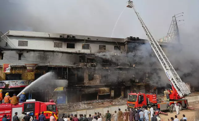 Firefighters try to control a massive fire that was broke out in a multi-story shopping mall in overnight, in Karachi, Pakistan, Sunday, Jan. 18, 2026. (AP Photo/Mohammad Farooq)