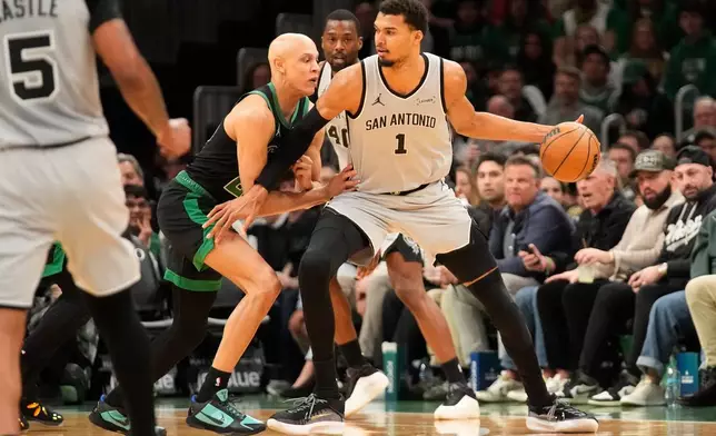 San Antonio Spurs forward Victor Wembanyama (1) is guarded by Boston Celtics guard Jordan Walsh (27) during the first half of an NBA basketball game Saturday, Jan. 10, 2026, in Boston. (AP Photo/Robert F. Bukaty)