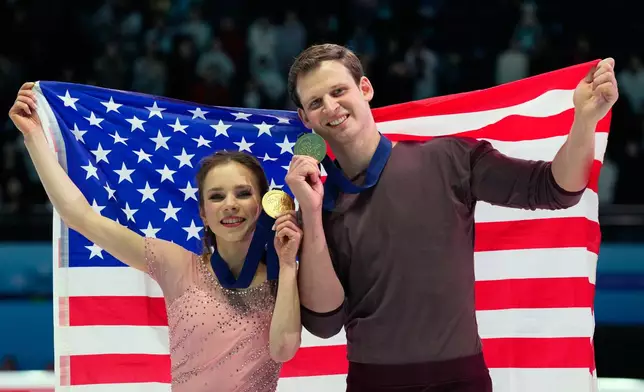 Gold medalists Alisa Efimova and Misha Mitrofanov of the United States celebrate with their national flag and medals after the Pairs Free Skating of the ISU Four Continents Figure Skating Championships in Beijing, China, Saturday, Jan. 24, 2026. (AP Photo/Vincent Thian)