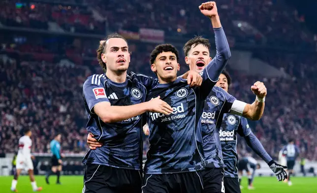 Frankfurt's Ayoube Amaimouni-Echghouyab celebrates scoring with Arthur Theate, left, and Robin Koch, right, during the Bundesliga soccer match between VfB Stuttgart and Eintracht Frankfurt in Stuttgart, Germany, Tuesday Jan. 13, 2026. (Tom Weller/dpa via AP)