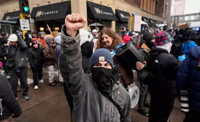 An immigration supporter raises his fist during a protest Saturday, Jan. 17, 2026, in Minneapolis. (AP Photo/Yuki Iwamura)