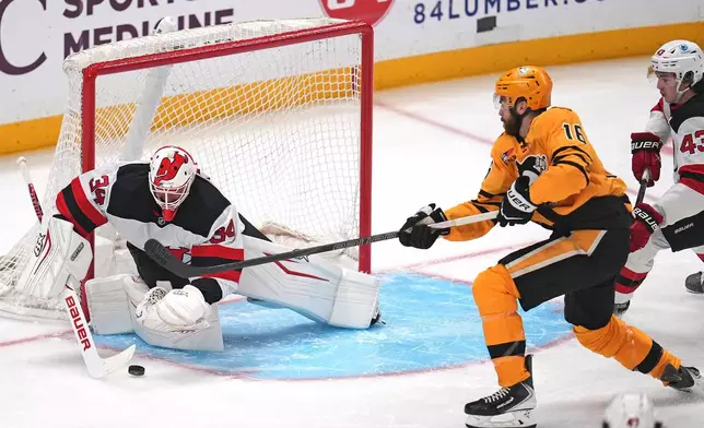 New Jersey Devils goaltender Jake Allen (34) blocks a shot by Pittsburgh Penguins' Justin Brazeau (16) with Luke Hughes (43) defending during the first period of an NHL hockey game in Pittsburgh, Thursday, Jan. 8, 2026. (AP Photo/Gene J. Puskar)