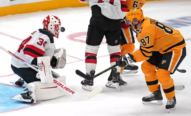 New Jersey Devils goaltender Jake Allen (34) blocks a shot by Pittsburgh Penguins' Sidney Crosby (87) during the first period of an NHL hockey game in Pittsburgh, Thursday, Jan. 8, 2026. (AP Photo/Gene J. Puskar)