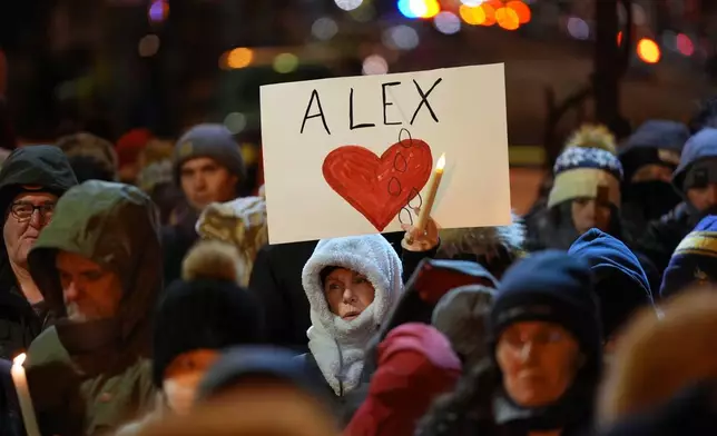 An attendee holds a sign during a vigil where Alex Pretti was shot and killed by federal immigration enforcement in Minneapolis, on Wednesday, Jan. 28, 2026. (AP Photo/Adam Gray)
