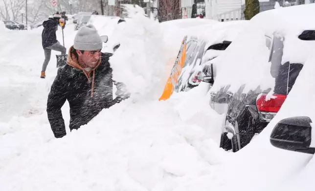 Residents dig out their cars in the South Boston neighborhood following a winter storm that dump more than a foot of snow across the region, Monday, Jan. 26, 2026, in Boston. (AP Photo/Charles Krupa)