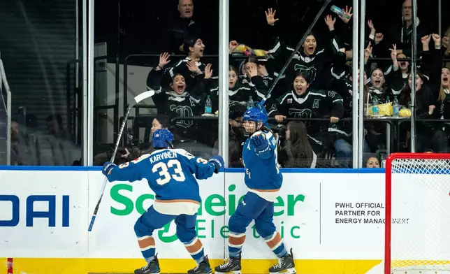Vancouver Goldeneyes' Sarah Nurse, right, celebrates after her goal against the Toronto Sceptres with teammate Michelle Karvinen (33) during the second period of a PWHL hockey game in Vancouver, British Columbia, Thursday, Jan. 22, 2026. (Ethan Cairns/The Canadian Press via AP)