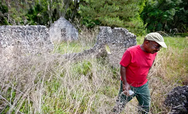 FILE - Ire Gene Grovner walks through remnants of the old slave's quarters at the Chocolate Plantation where his ancestors lived some eight generations ago on Sapelo Island, Ga., on May 16, 2013. (AP Photo/David Goldman, File)