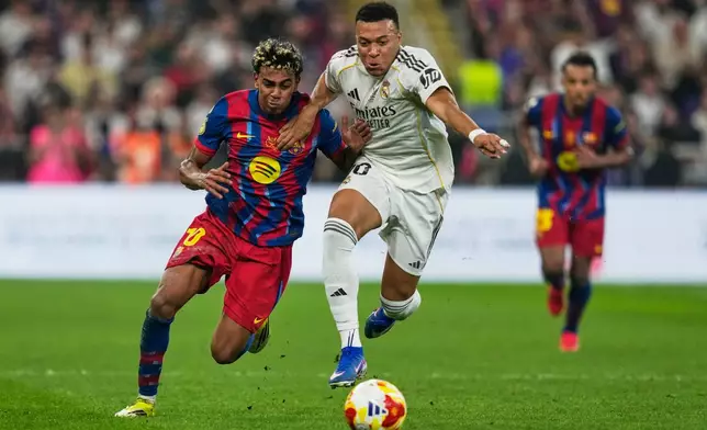 Barcelona's Lamine Yamal, left, duels for the ball with Real Madrid's Kylian Mbappe during the Spanish Super Cup final soccer match at King Abdullah Sports City Stadium in Jeddah, Saudi Arabia, Sunday, Jan. 11, 2026. (AP Photo/Altaf Qadri)
