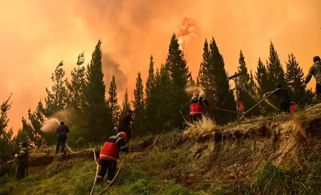Firefighters battle flames as wildfires blaze in El Hoyo, Patagonia, Argentina, Thursday, Jan. 8, 2026. (AP Photo/Maxi Jonas)