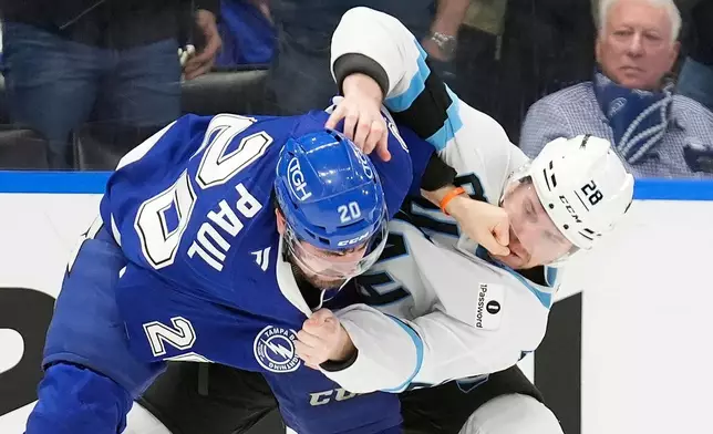 Tampa Bay Lightning left wing Nick Paul (20) punches Utah Mammoth defenseman Ian Cole (28) in the face as they fight during the second period of an NHL hockey game Monday, Jan. 26, 2026, in Tampa, Fla. (AP Photo/Chris O'Meara)