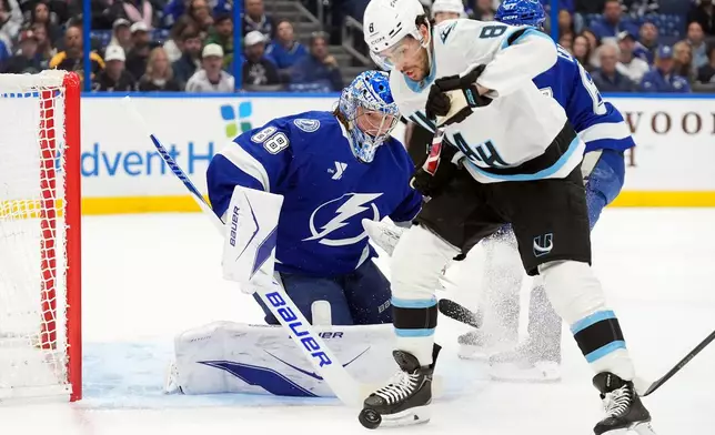 Tampa Bay Lightning goaltender Andrei Vasilevskiy (88) stops a shot by Utah Mammoth center Nick Schmaltz (8) during the first period of an NHL hockey game Monday, Jan. 26, 2026, in Tampa, Fla. (AP Photo/Chris O'Meara)
