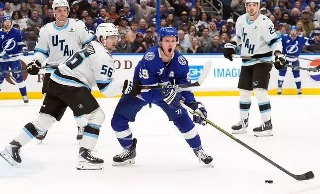 Tampa Bay Lightning center Jake Guentzel (59) looks for a pentalty call as he battles with Utah Mammoth right wing Kailer Yamamoto (56) during the second period of an NHL hockey game Monday, Jan. 26, 2026, in Tampa, Fla. (AP Photo/Chris O'Meara)