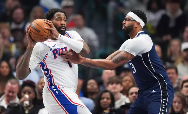 Philadelphia 76ers center Andre Drummond, left, is guarded by Dallas Mavericks forward Anthony Davis during the first half of an NBA basketball game Thursday, Jan. 1, 2026, in Dallas. (AP Photo/Julio Cortez)