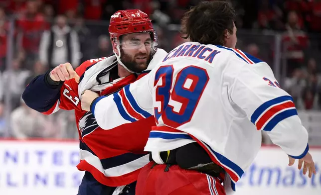 Washington Capitals right wing Tom Wilson (43) fights New York Rangers center Sam Carrick (39) during the second period of an NHL hockey game, Wednesday, Dec. 31, 2025, in Washington. (AP Photo/Nick Wass)