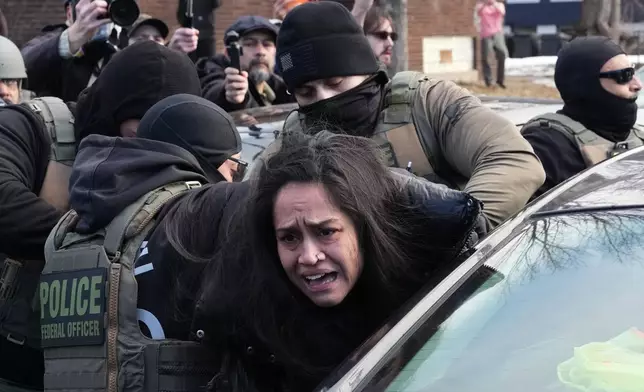 A person is detained by federal agents near the scene where Renee Good was fatally shot by an ICE officer last week, Tuesday, Jan. 13, 2026, in Minneapolis. (AP Photo/Adam Gray)