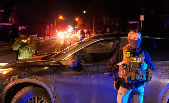 Federal immigration officers at the scene of a reported shooting Wednesday, Jan. 14, 2026, in Minneapolis. (AP Photo/John Locher)