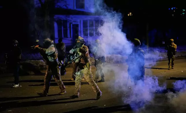 Federal immigration officers shoot pepper balls as tear gas is deployed at the scene of a reported shooting Wednesday, Jan. 14, 2026, in Minneapolis. (AP Photo/John Locher)