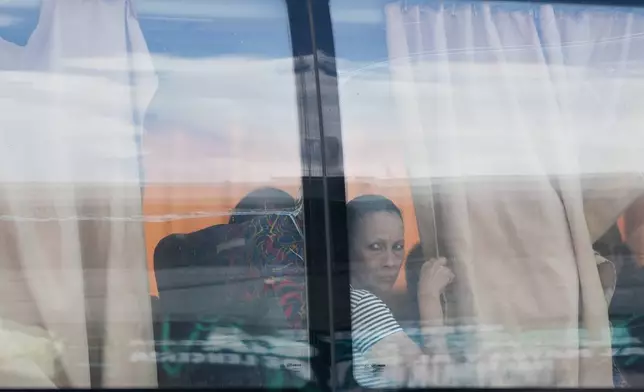 Relatives arrive by bus to the funeral of military killed in the U.S. military operattion to capture former Venezuelan President Nicolas Maduro in Caracas, Venezuela, Wednesday, Jan. 7, 2026. (AP Photo/Ariana Cubillos)