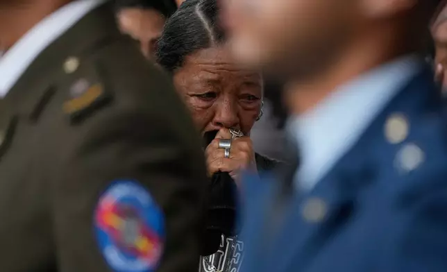Relatives of soldiers killed in the U.S. raid to capture Venezuelan President Nicolas Maduro and his wife mourn during the soldiers' funeral in Caracas, Venezuela, Wednesday, Jan. 7, 2026. (AP Photo/Ariana Cubillos)